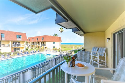 Enjoy morning coffee on the balcony with peaceful pool and ocean views.