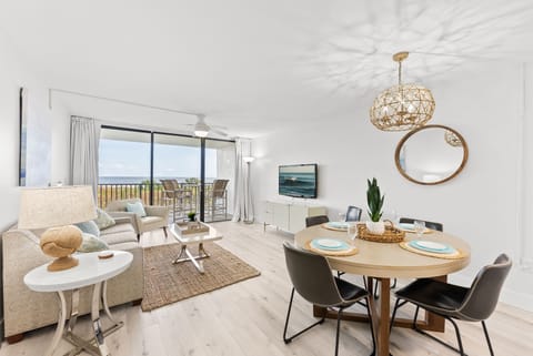 Elegant open-concept dining and living area with ocean views, stylish decor, and natural light.