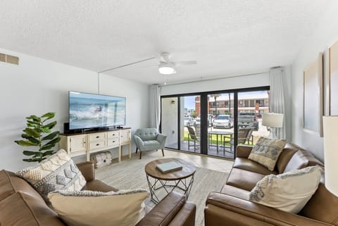 Kick back in this sun-filled living room with cozy seating, a smart TV, and sliding doors that open straight to your private balcony