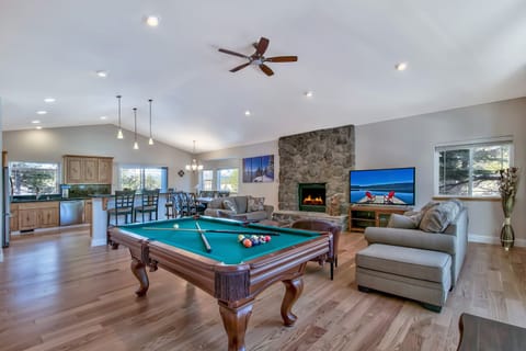 Unwind in your spacious entertainment haven with billiards, cozy fireplace seating, and open kitchen perfect for game nights.