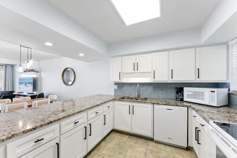 A chef's dream kitchen with sleek white cabinetry, granite countertops, and modern appliances.