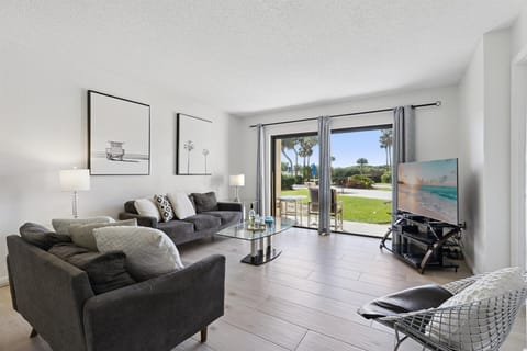 Living room with 50" TV and walkout to your private patio that's 15 steps to the pool