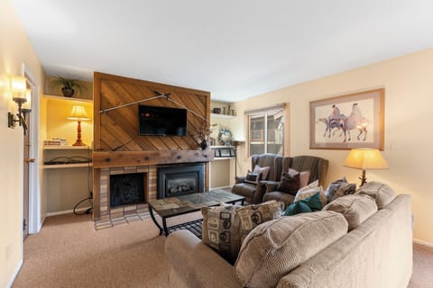 Curl up by the warm fireplace in this inviting living room, where rustic wood accents meet comfortable seating. Natural light fills the space, creating the perfect spot for your mountain getaway relaxation.