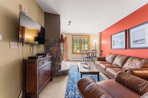 Settle into plush leather seating by your stone fireplace, where warm lighting and bold accent walls create the perfect atmosphere for relaxation.