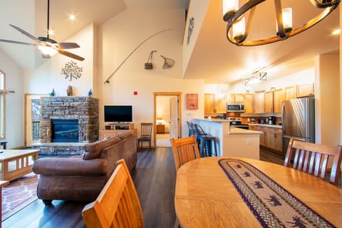 Living area featuring hardwood flooring, vaulted ceilings, ample seating, gas fireplace, flat screen TV and access to the private balcony.