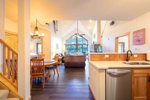 Living area featuring hardwood flooring, vaulted ceilings, ample seating, gas fireplace, flat screen TV and access to the private balcony.