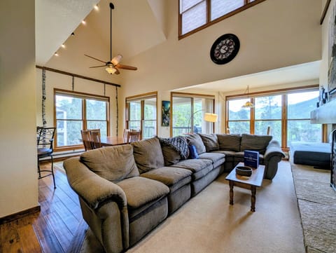 Relax in your bright, vaulted living space with soaring ceilings, cozy sofas, and sweeping mountain views through every window—perfect for gathering after a day exploring.