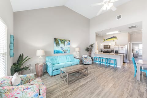 Unwind in your bright, coastal-themed living space with turquoise sofa and tropical touches that invite pure relaxation.