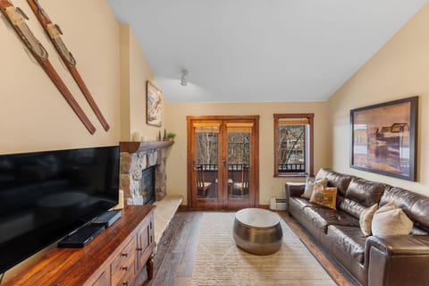 Sink into buttery leather sofas by the crackling fireplace, where warm wood accents and mountain views create your perfect alpine retreat.