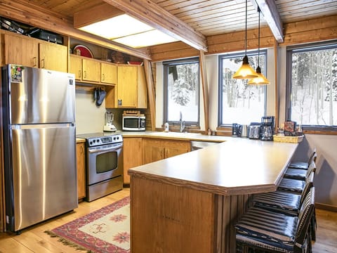 Kitchen - Kitchen with island chairs, stove, microwave, sink, and refrigerator.