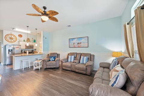 Sink into plush recliners under tropical ceiling fans while your chef prepares meals in the open kitchen nearby.