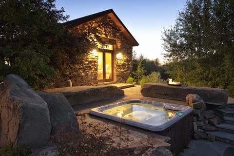 Picture yourself soaking in your private hot tub as twilight paints the sky, surrounded by natural stone and lush greenery. This magical outdoor sanctuary offers complete tranquility.