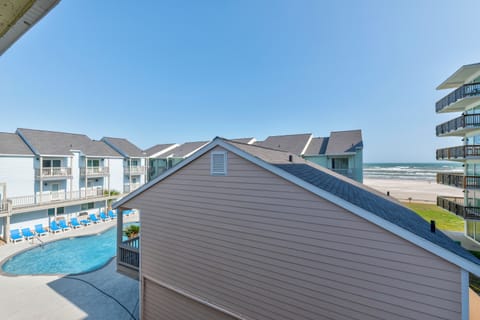 Beachfront property complex with swimming pool and direct beach access on a clear day.