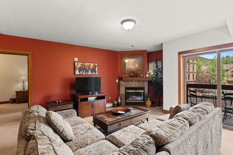 Sink into plush sofas by your crackling fireplace and enjoy mountain views from your private balcony in this welcoming living space.