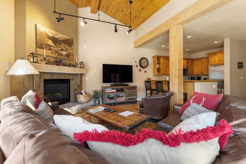 Cozy up in your mountain-style living room with leather seating, rustic beams, and fireplace warmth.