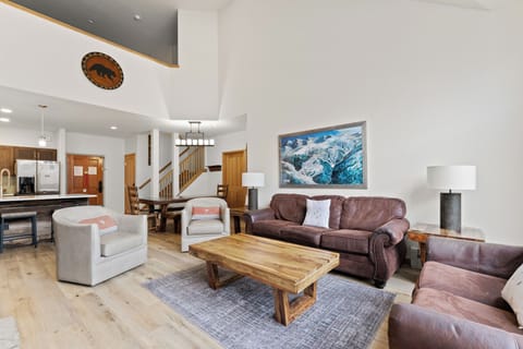 Spacious living area including vaulted ceilings, stone fireplace, floor-to-ceiling windows, and a queen sleeper sofa.