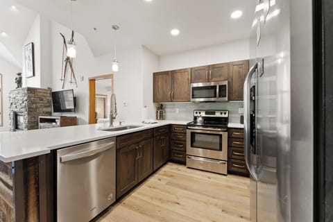 Full kitchen featuring stainless steel appliances and breakfast bar seating.