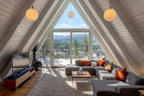 The main living room features soaring windows with an unbeatable view, a large sectional sofa, access to the large deck.