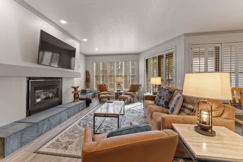 Unwind in your elegant living room where warm leather seating and a crackling fireplace create the perfect atmosphere for cozy evenings together.