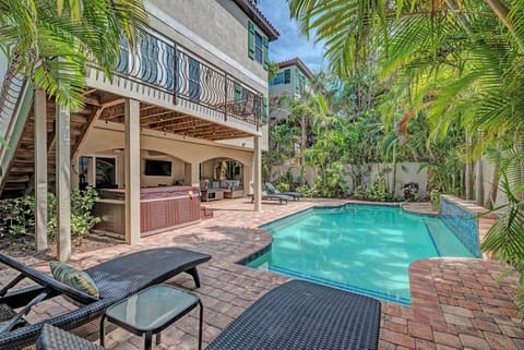 Pool deck with view of heated pool along with hot tub. Accompmanied by a pool lounge chairs and plenty of seating