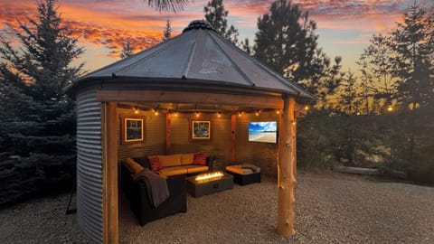 Cozy up in a custom grain-bin retreat with firelight and TV