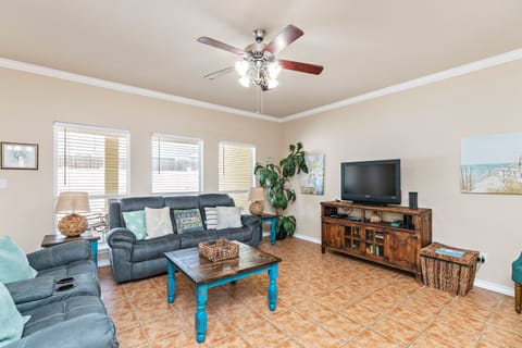 Relax in your spacious living room with cozy sectional seating, entertainment center, and refreshing ceiling fan overhead.