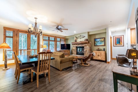 Relax in your spacious mountain retreat featuring warm wood accents, a cozy stone fireplace, and open living area perfect for family gatherings.