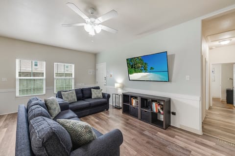 Sink into comfortable seating and unwind with your favorite shows on the large TV in this bright, airy living room.