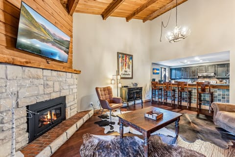 Living Room: Couch, 2 chairs, gas fireplace, Smart TV, access to balcony, open layout to kitchen 
