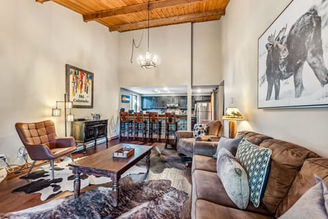 Living Room: Couch, 2 chairs, gas fireplace, Smart TV, access to balcony, open layout to kitchen 
