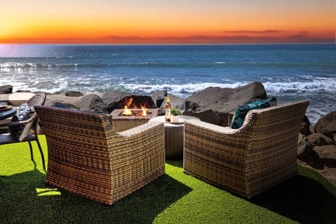 Beachfront fire pit seating creates the perfect oceanside retreat for evening gatherings with stunning sunset views.