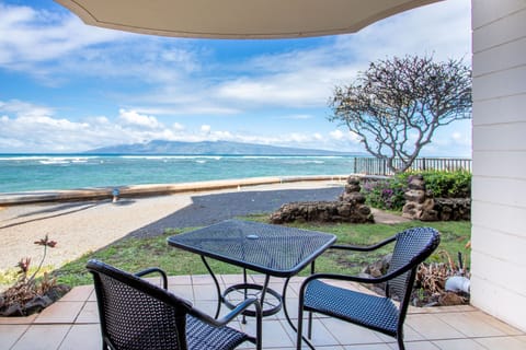 Stunning oceanfront patio frames turquoise waters and distant mountains. Relax at your private table with island breezes and endless blue horizons just steps away.