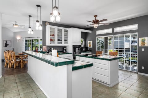 Roomy kitchen with a center island stove top and bar.