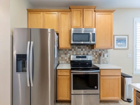 Modern kitchen with stainless steel appliances and warm cabinetry!