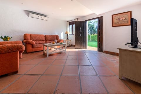 Sofás, table and TV of Hierbabuena living room in Hacienda Roche Viejo in Conil