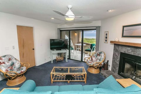 - Cozy up in the living room with a fireplace, flat screen TV, and plush tropical seating
- Sliding glass doors open to a private patio with serene nature views
- Ceiling fan and soft carpeting add comfort for relaxing evenings