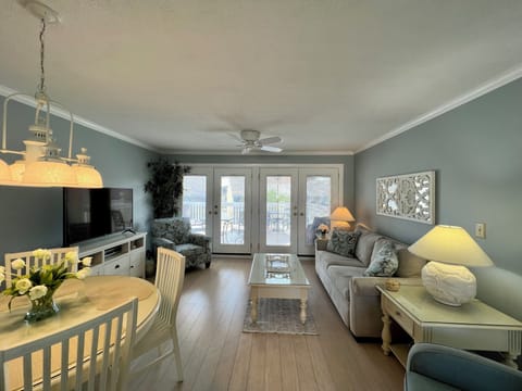 Your coastal retreat features comfy seating, entertainment center, and balcony doors opening to sea breezes and stunning water views.