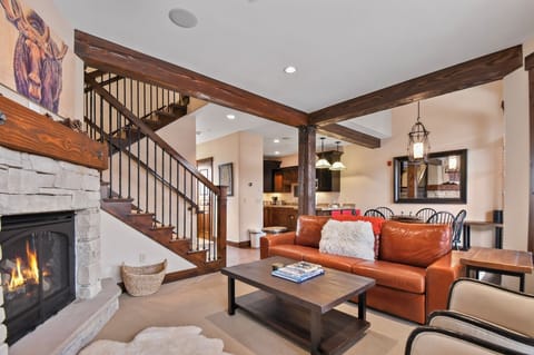 Unwind by your crackling fireplace in this rustic-chic living room, where warm leather seating and exposed beams create the perfect mountain retreat atmosphere.
