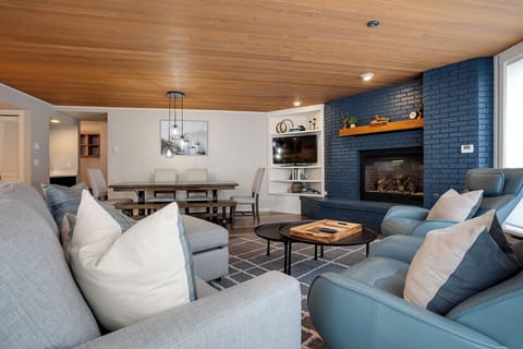 Sink into plush seating by the crackling fireplace, where your conversations flow as smoothly as the warm wood ceiling above.