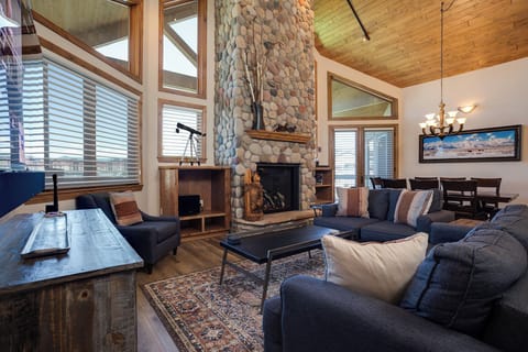 Sink into plush sofas beside your crackling stone fireplace, where rustic wood beams meet modern comfort in this stunning mountain retreat.