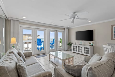 Unwind in your coastal retreat where plush sofas face ocean views and bright blue chairs await on your private balcony.