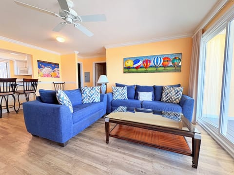 Unwind in your cheerful living space with comfortable blue sofas and colorful hot air balloon artwork brightening sunny afternoons.