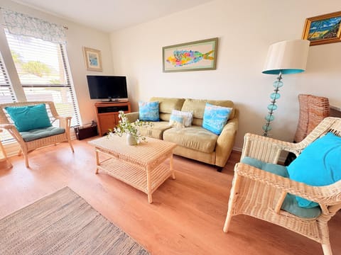 Unwind in this coastal living room with wicker seating, turquoise accents, and natural light streaming through your windows.
