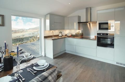 Ground floor: Open-plan kitchen/dining area with underfloor heating and large floor to ceiling window overlooking the surrounding countryside