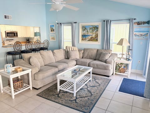 Settle into your spacious living room where coastal blues meet comfortable furnishings, creating your perfect beachside retreat.
