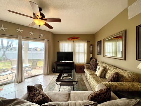 Relax in your spacious living room with comfortable seating, overhead fan, and sliding doors opening to your private patio.