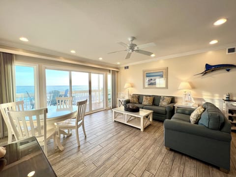 Relax in this bright, coastal living room with stunning gulf views through floor-to-ceiling windows and comfortable seating.