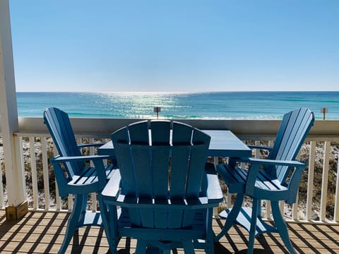 Relax in coastal blue Adirondack chairs on your private deck with stunning gulf views and gentle waves.