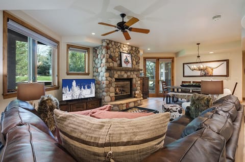 Sink into plush leather sofas while your fireplace crackles warmly and natural light streams through expansive windows.