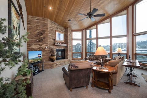 Relax in your cozy living room with a warm fireplace, panoramic windows, and rustic charm.